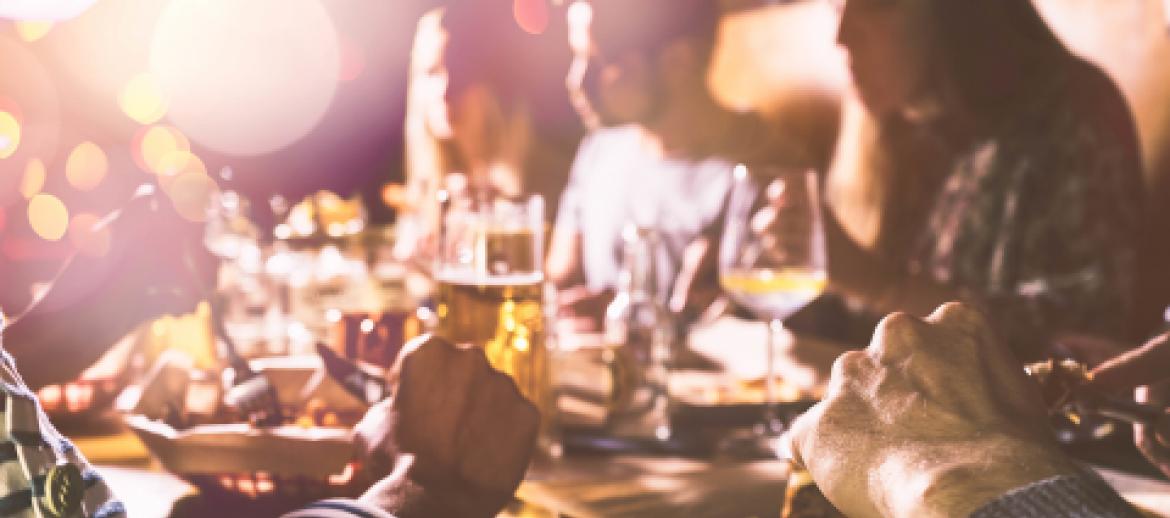 Friends sitting around a table eating and drinking in a restaurant 