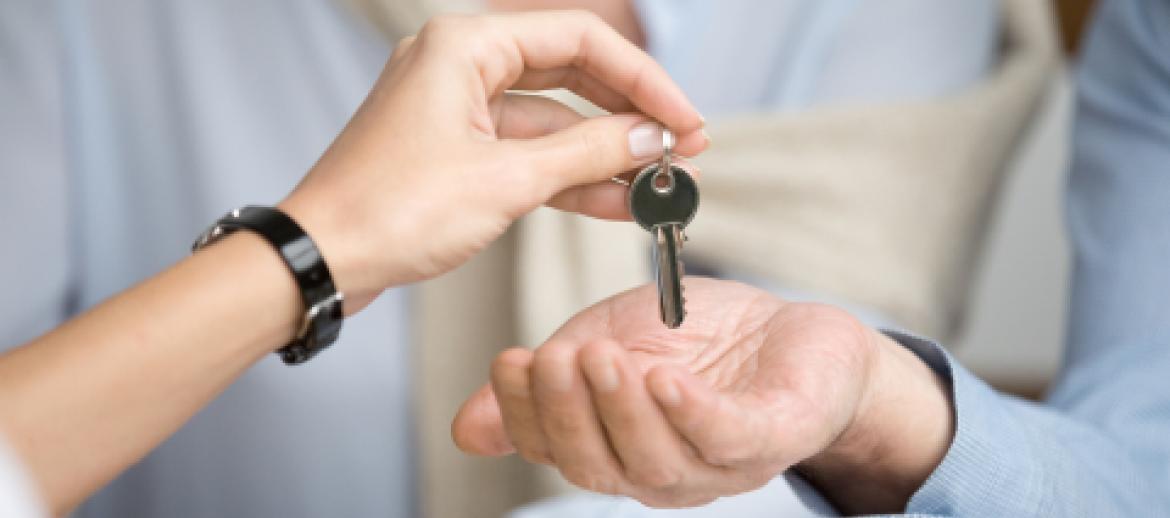 Businesswoman passing keys to businessman