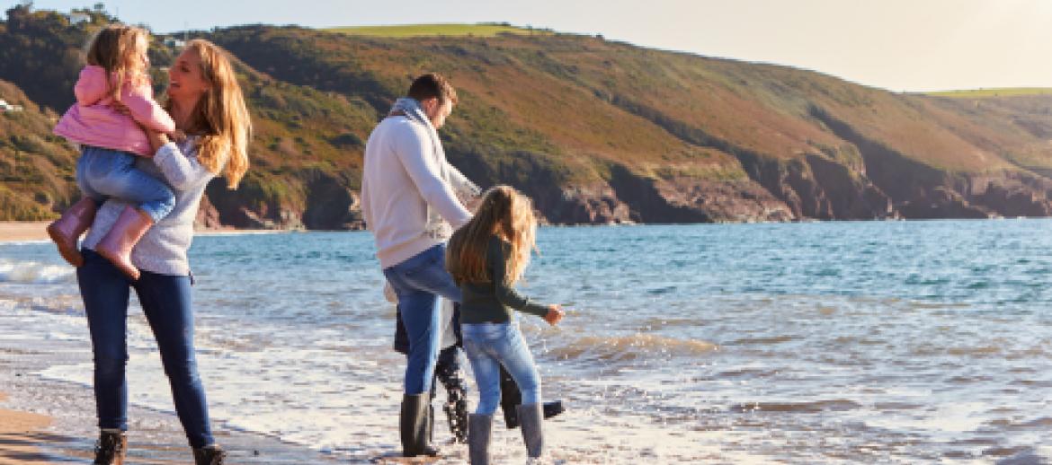 Married couple with children playing at seaside