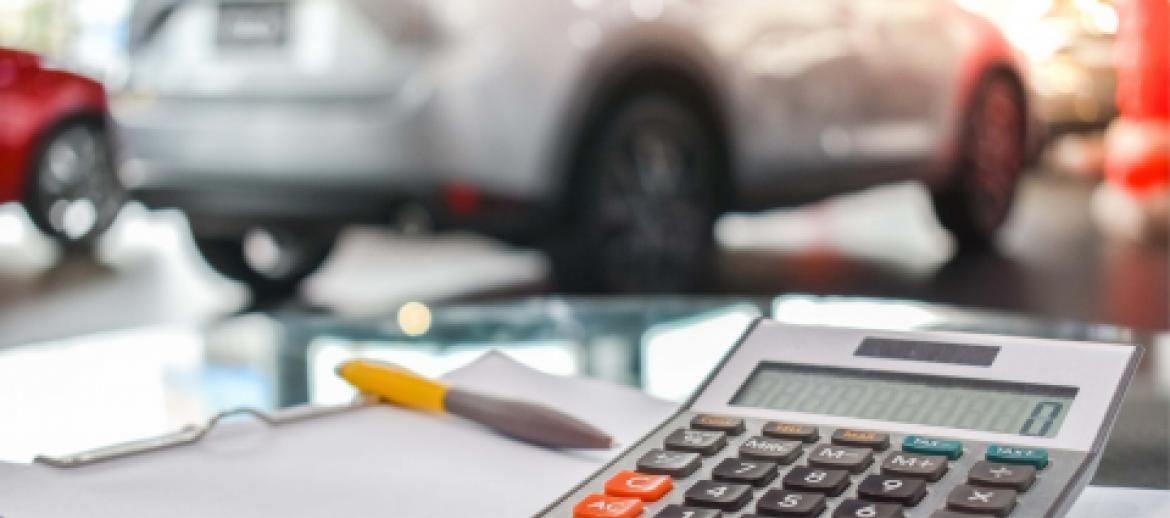 cars in cart show room with calculator in foreground