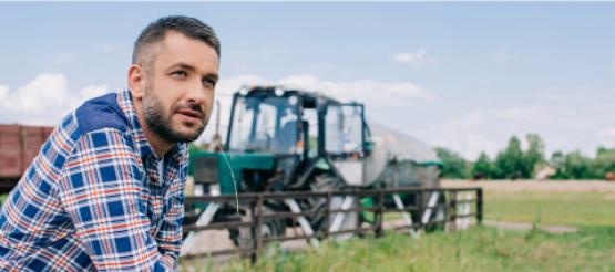 Farmer next to tractor in field