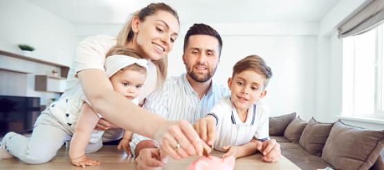 Parents with children putting money into a piggy bank