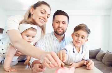 Parents with children putting money into a piggy bank