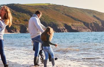 Married couple with children playing at seaside