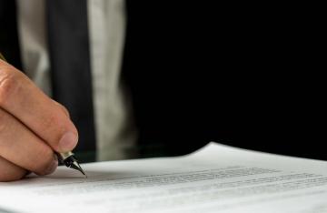 man signing document