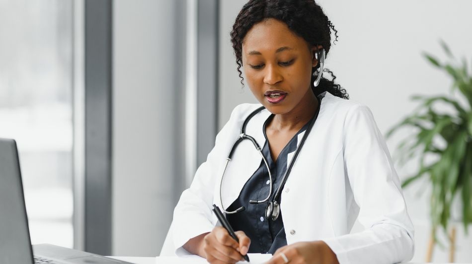 Female GP wearing stethoscope looking at patient notes