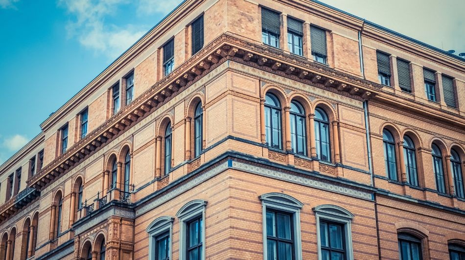 Historic sandstone office building with arched windows and detailed classical architecture.
