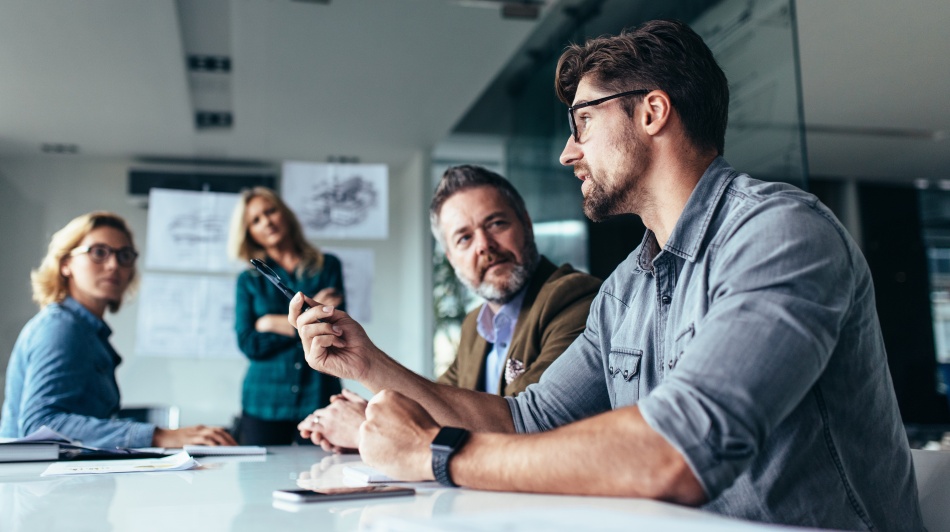 Business team discussing a project during a meeting in a modern office conference room.