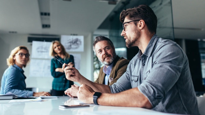 Business team discussing a project during a meeting in a modern office conference room.