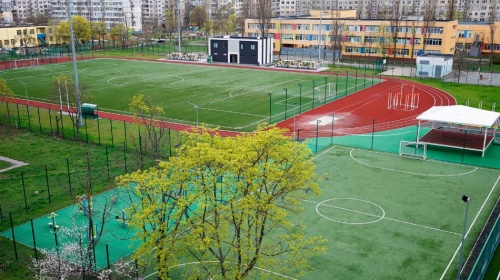 Modern school sports complex with football pitches, running track, and outdoor athletic facilities