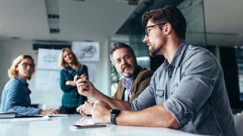 Business team discussing a project during a meeting in a modern office conference room.