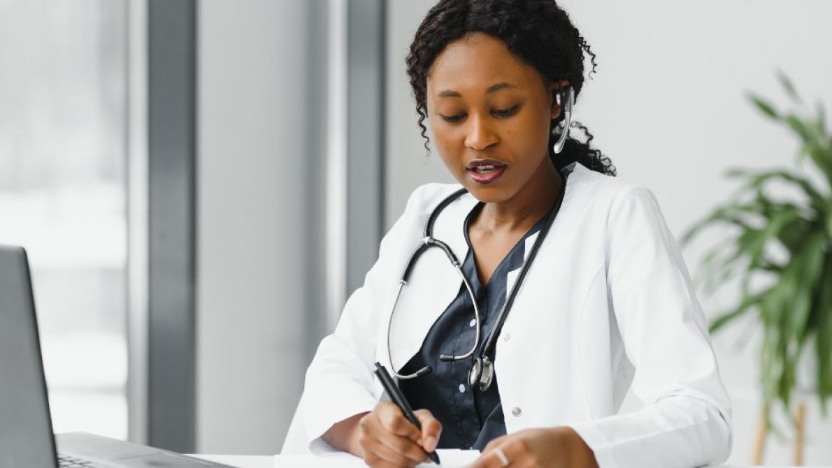 Female GP wearing stethoscope looking at patient notes