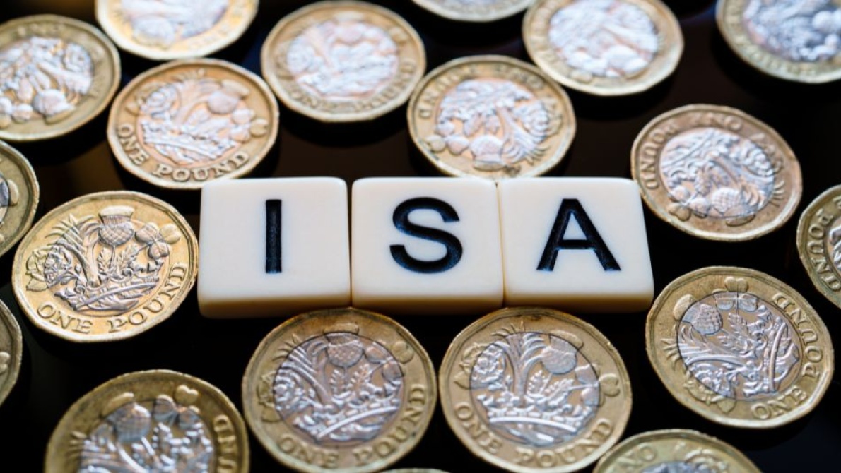 Wooden tiles spelling “ISA” surrounded by UK one‑pound coins, representing savings accounts.