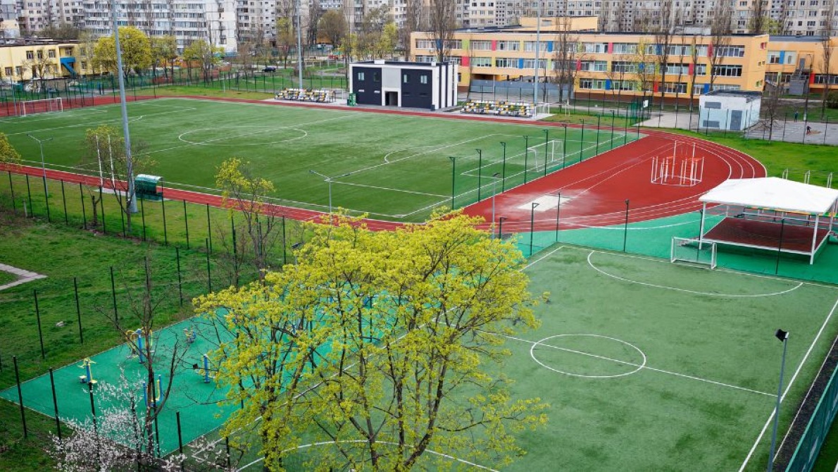 Modern school sports complex with football pitches, running track, and outdoor athletic facilities