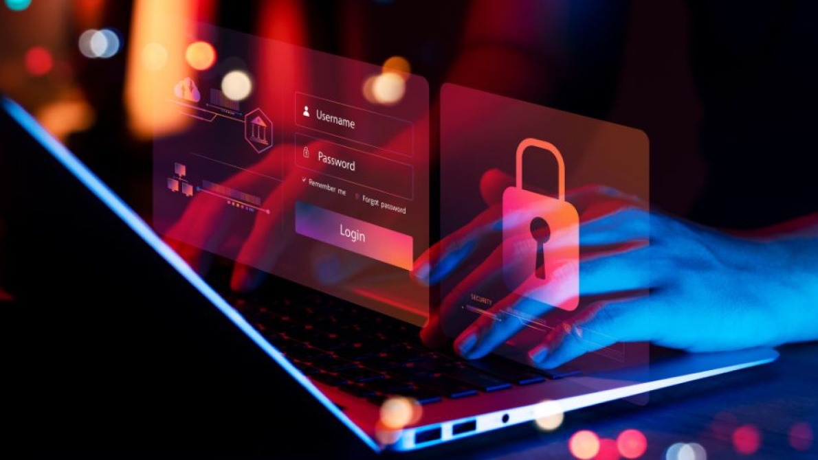 Cybersecurity concept showing hands typing on a laptop with digital login credentials and padlock security icons overlayed on screen.