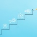Hand sketching a rising staircase chart toward a target, symbolizing business growth and strategic planning.