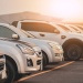 Row of white pickup trucks parked in a fleet vehicle lot at sunset.