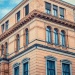 Historic sandstone office building with arched windows and detailed classical architecture.