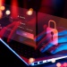 Cybersecurity concept showing hands typing on a laptop with digital login credentials and padlock security icons overlayed on screen.