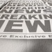 Stack of newspapers featuring large “Breaking News” headlines, photographed from a low angle with selective focus.
