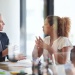 Business professionals in a meeting room discussing documents across a conference table.